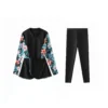 Flat-lay of the full three-piece teal tropical swimwear set: back-zip onesie, solid shorts, and patterned sarong.