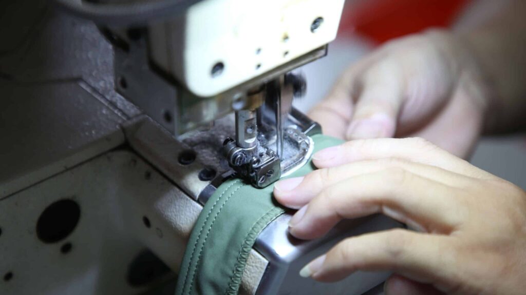Skilled workers sewing custom swimwear samples in a professional garment factory