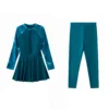 Front flat-lay of the teal swimsuit top, featuring a quarter-zip front closure, tropical-print raglan sleeves, and a peplum waist.
