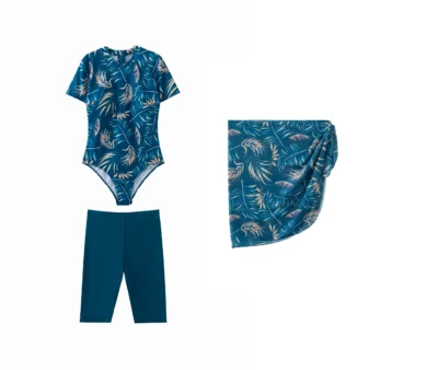 Front flat-lay of the teal tropical print short-sleeve onesie and matching solid teal swim shorts.