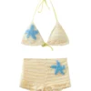 Close-up view of a blue sequined starfish patch appliqué on highly textured pale yellow smocked fabric.