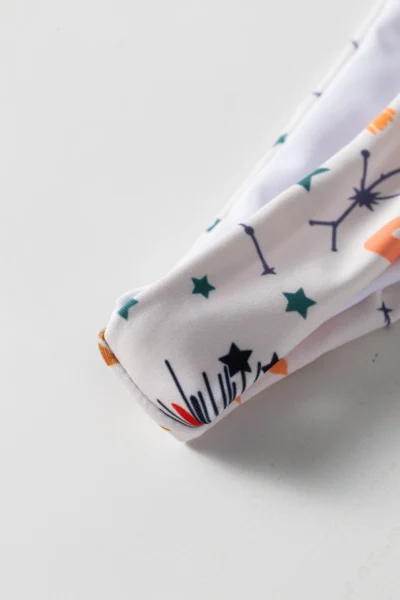 Macro close-up of the white celestial print bikini fabric edge showing stars and constellation pattern.