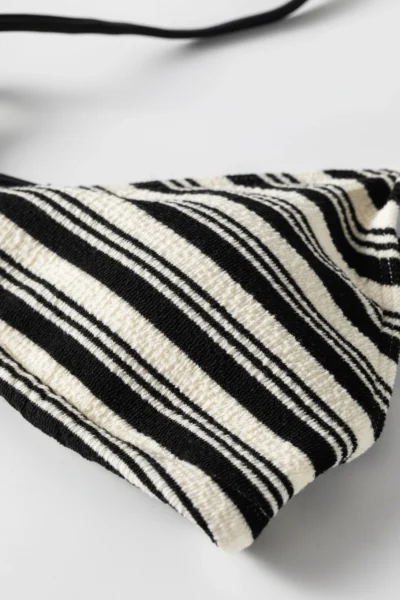 Close-up of black and white striped terry fabric showing the white inner lining peeking out from the edge.