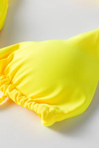 A flat-lay shot displaying the backside of the yellow bikini set. It reveals the halter neck tie straps, the lace-up or tie-back construction of the top, and the slight ruched detailing on the high-cut bottom.