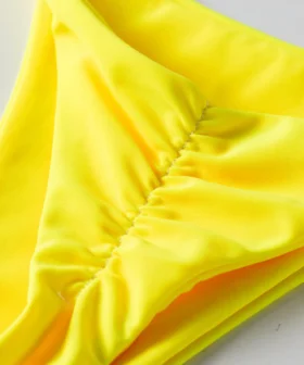 Macro close-up of the ruched stitching detail inside the yellow bikini bottom.