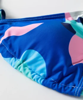 Back flat-lay of the abstract print long-sleeve cover-up and triangle bikini set, revealing the bikini top's white inner lining.