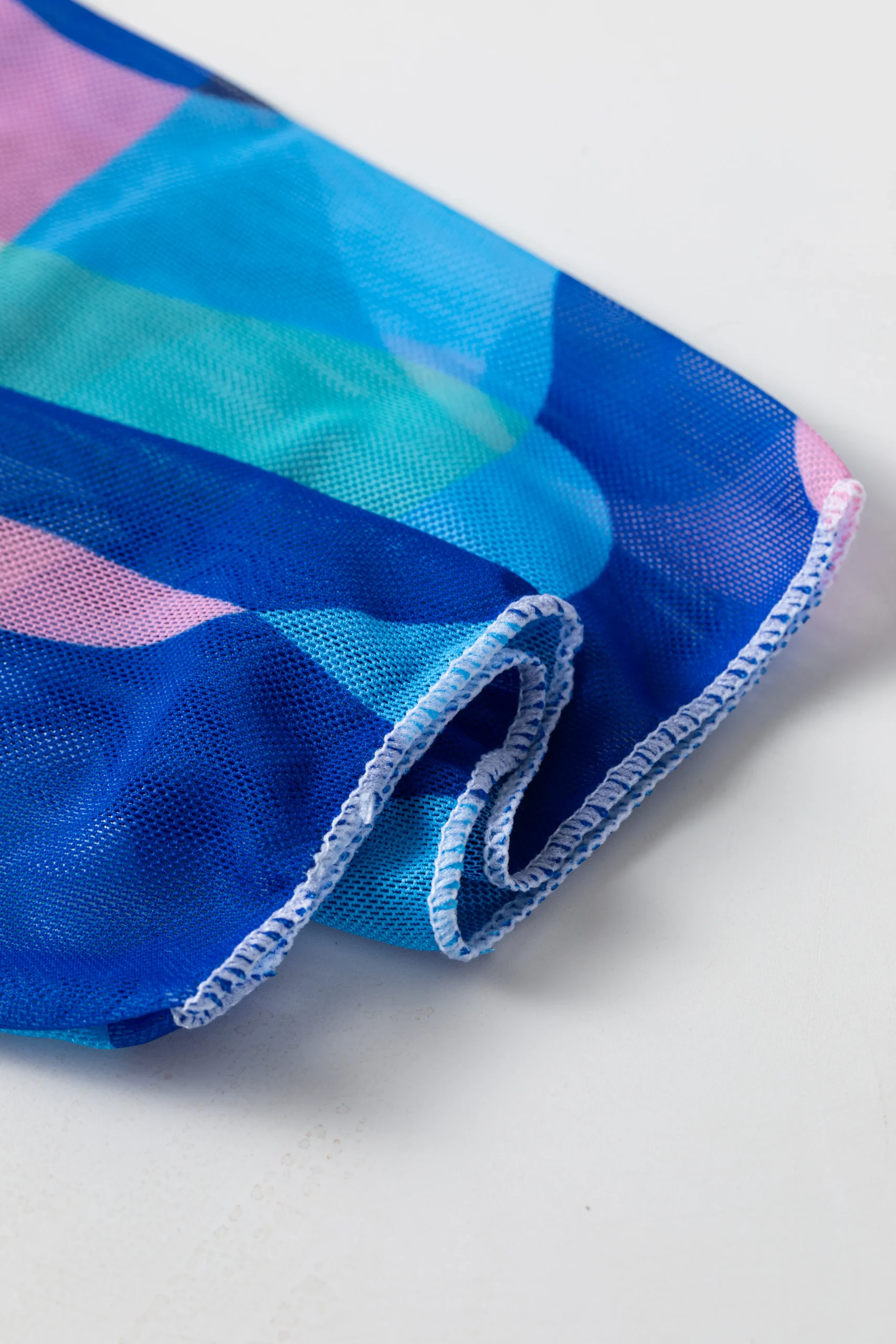 Front flat-lay of the abstract print triangle bikini set, showing the white inner lining of the top and the solid patterned bottom.