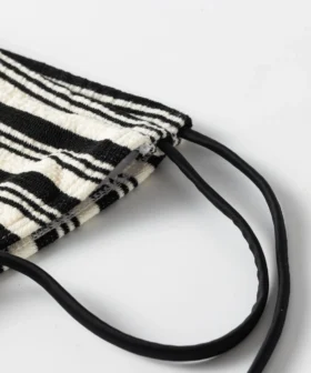 Close-up of black and white striped knitted fabric with a thick, textured finish.