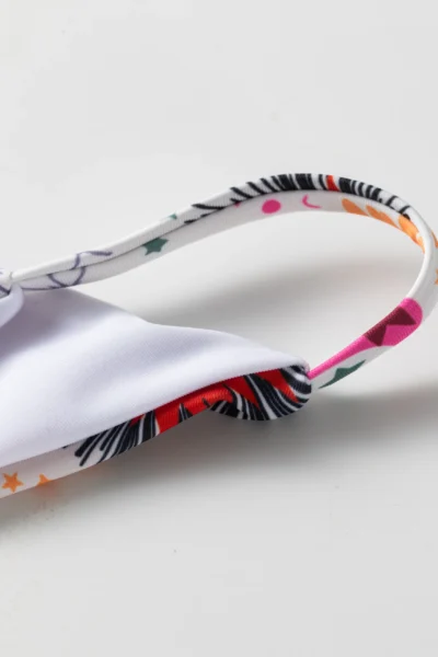 Macro close-up of a printed strap connected to the white inner lining of the bikini top.
