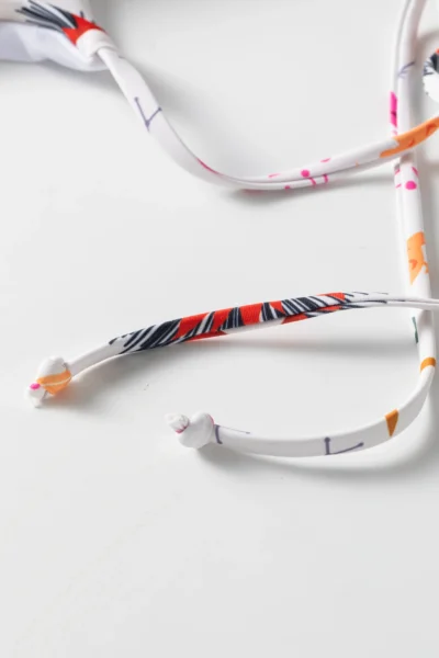 Macro close-up of the knotted ends of the printed bikini tie strings.