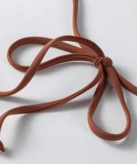 Back flat-lay of the ivory textured bikini set showing the white inner lining, gold front ring, and brown ties.