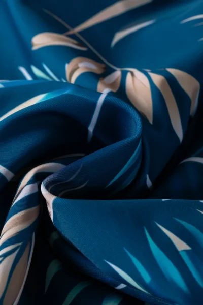 Macro close-up of the abstract print bikini bottom edge, showing double-stitched topstitching and a white inner lining.