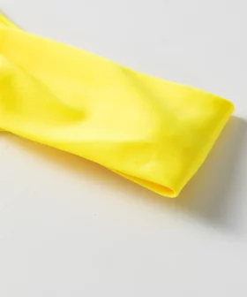 Macro close-up of smooth solid yellow bikini fabric edge and fold.