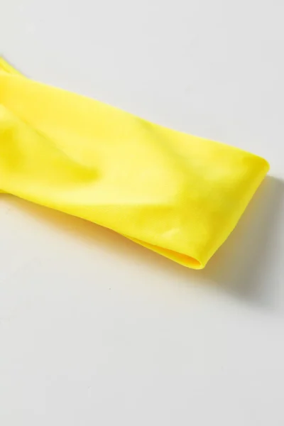 Macro close-up of smooth solid yellow bikini fabric edge and fold.