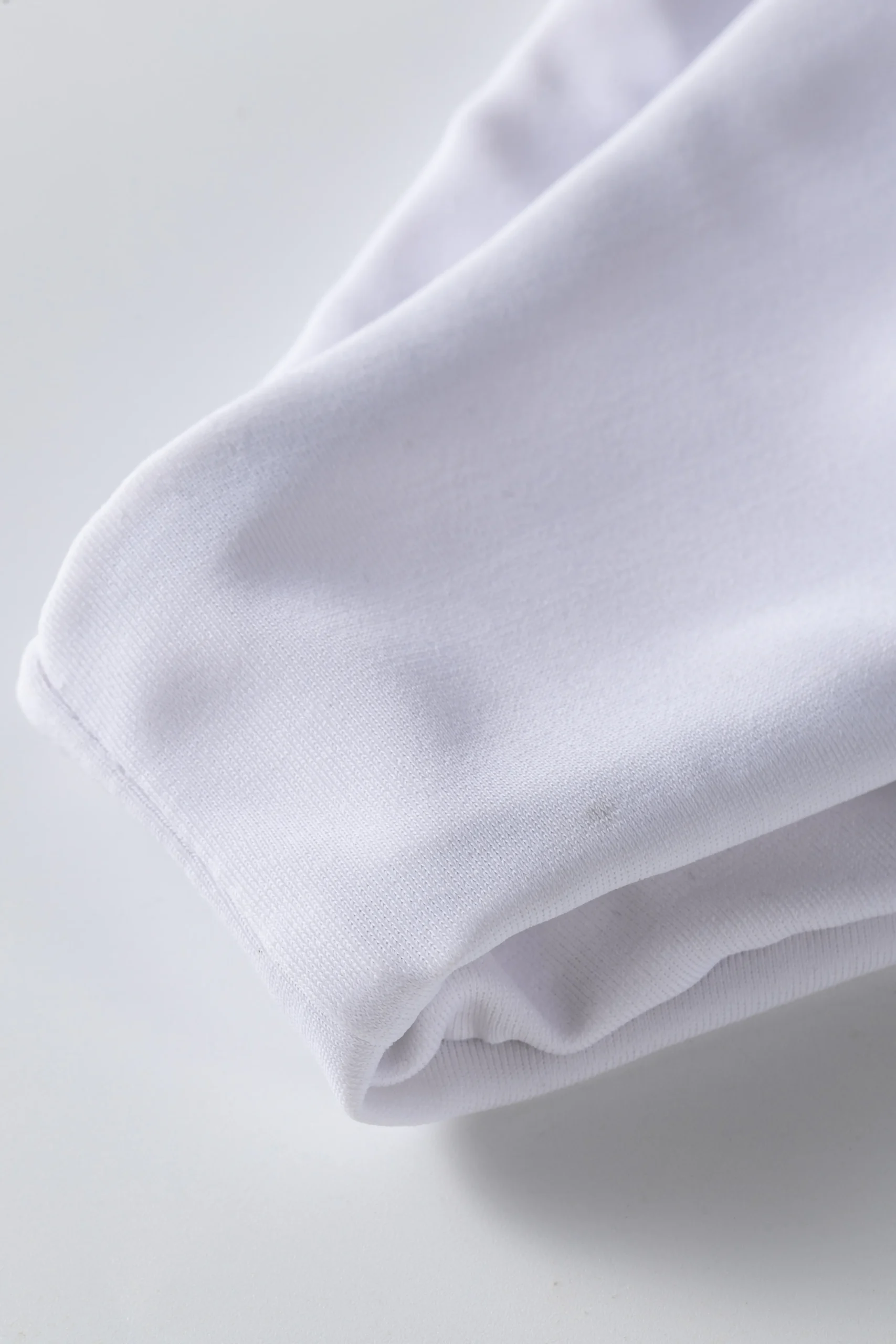 Macro close-up of the black front zipper and round crew neckline on the black swimsuit top.