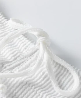 Macro close-up of two flat white elastic bikini straps with zigzag edge stitching