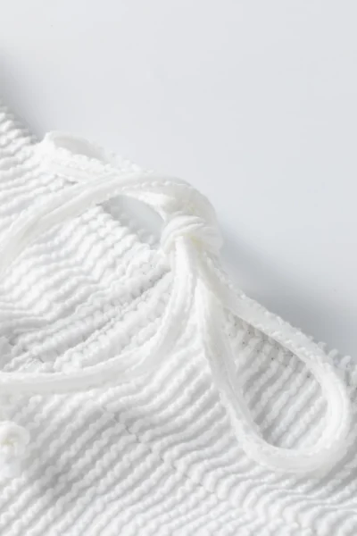 Macro close-up of two flat white elastic bikini straps with zigzag edge stitching