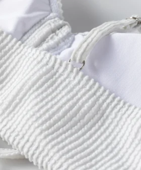 Close-up detail of a thin white tubular bikini string tied tightly into a knot.